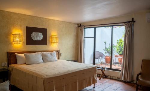 a bedroom with a bed and a large window at Parador del Dominico in Oaxaca City