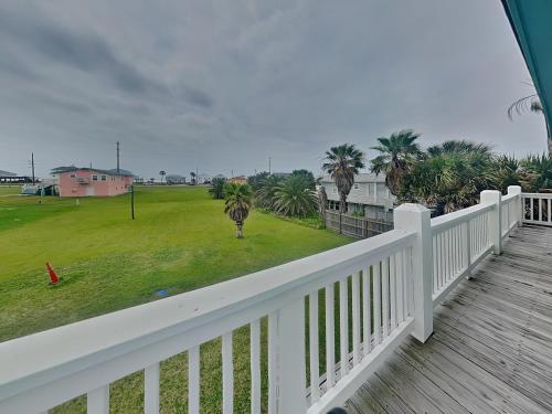 a balcony with a view of a yard with palm trees at Sundancers in Galveston