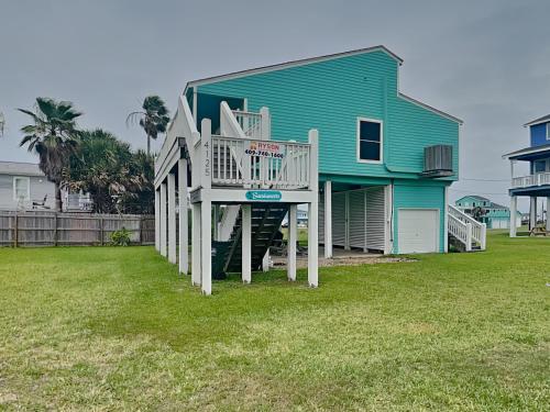 a house with a large deck in front of it at Sundancers in Galveston