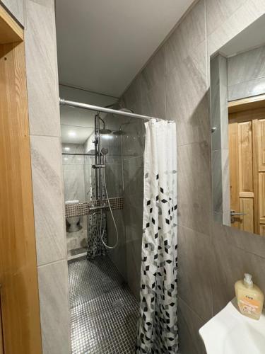 a bathroom with a shower with a shower curtain at Butas pačiame miesto centre in Telšiai