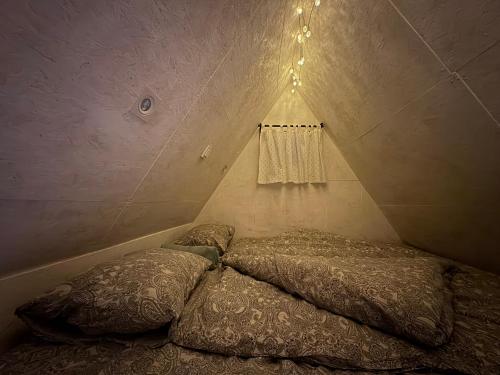 a bed in a small room with a curtain at Králíkova chatka in Kaliště
