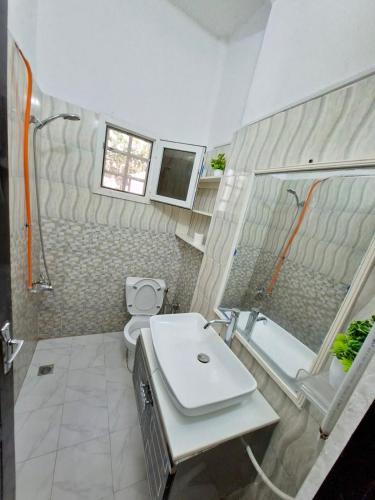 ein Badezimmer mit Waschbecken, Toilette und Badewanne in der Unterkunft Téranga Home Cosy & Spacieux à 600m de la plage in Dakar
