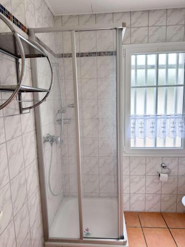 a shower with a glass door in a bathroom at La Pierre Lotie in Saint-Denis-dʼOléron