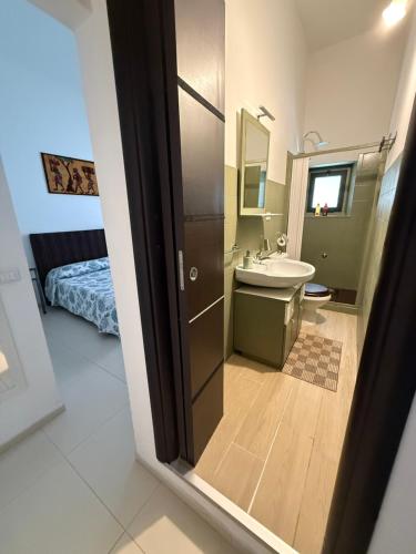 a bathroom with a sink and a toilet and a mirror at Casa Bucalo 2, Taormina in Taormina