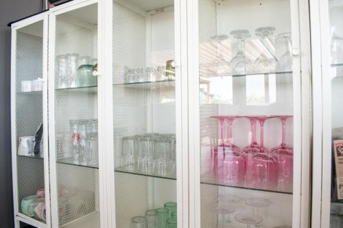 a white cabinet filled with lots of glass vases at Pepi Sobe in Čepin