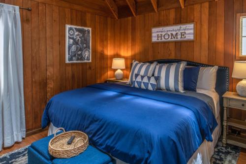 a bedroom with a blue bed in a room with wooden walls at 3796 The Madden Suite in Carmel