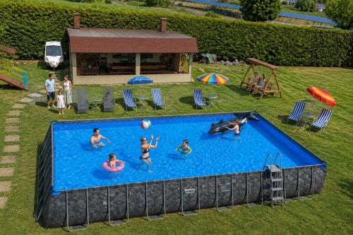 a group of people playing in a swimming pool at VILLA DORA - CENTRUM,BASEN PODGRZEWANY,JACUZZI SAUNA, Plac zabaw, Parking in Mielno