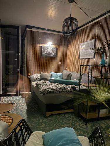 a living room with a couch and a glass table at TINY-HOUSE mit Alpen- Stadt- und Poolblick , WLAN in Passau