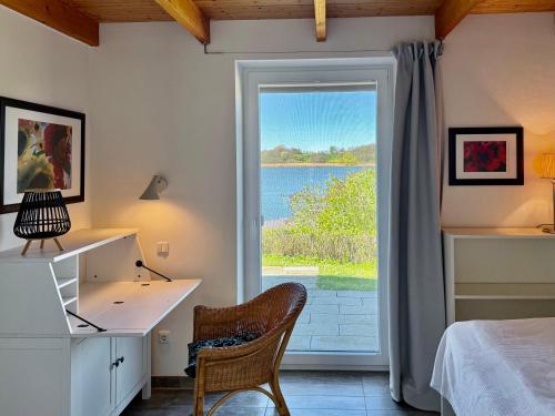 a bedroom with a bed and a desk and a window at Schlei Resort Marina Hülsen in Kosel