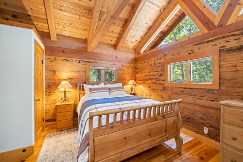 a bedroom with a bed in a log cabin at 2 Riverfront Cabins, 200 Acres Near Plumas Forest in Sloat