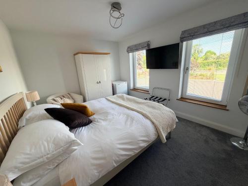 a bedroom with a bed with white sheets and pillows at Ardbrin Lodge Guest Accommodation in Dunadry