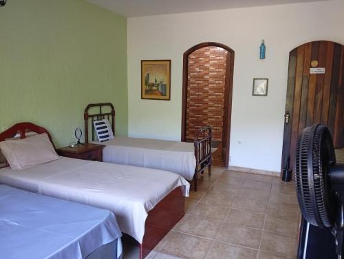 a room with two beds in a room with a doorway at Pousada rotas e ritmos in São Paulo