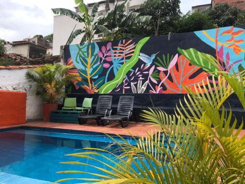 a mural on a wall next to a swimming pool at The Best Adventure Hostel in San Gil