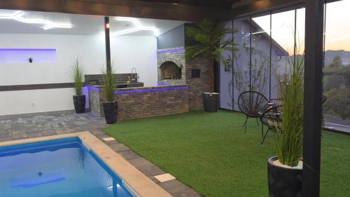 a backyard with a swimming pool and green grass at Vikendica Tuzla baracuda bazen in Slavinovići