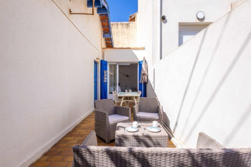 a balcony with chairs and tables on a building at Valras-Loc - Maison de Pecheur in Valras-Plage