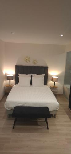 a bedroom with a large white bed with two lamps at Studio Coeur Basque in Iholdy