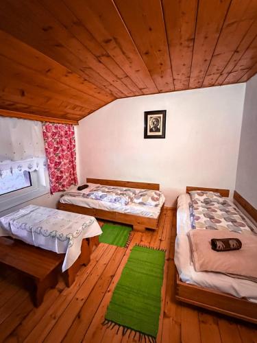 two beds in a room with wooden floors at Siedlisko u Jana in Korbielów