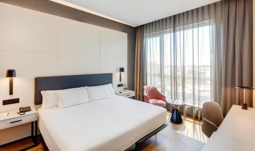a hotel room with a bed and a large window at Sercotel Sorolla Palace in Valencia