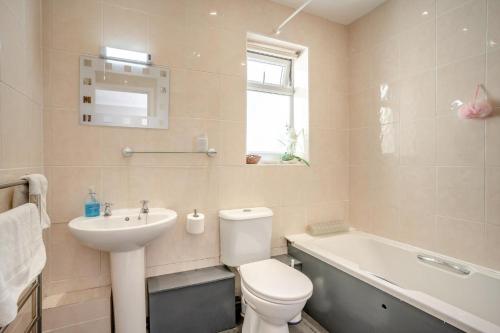 a bathroom with a toilet and a sink and a bath tub at 2 Bed in Mumbles oc-hh505 in The Mumbles