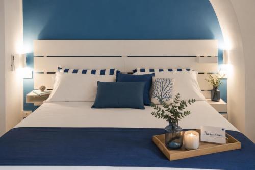 a bedroom with a large white bed with a blue ceiling at Harmonia Rooms by Italy Home Experience in Civitavecchia