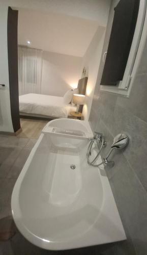 a bathroom with a white sink and a bed at Studio Coeur Basque in Iholdy