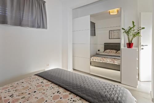 a bedroom with a bed and a mirror at Apartment Stocic in Rogoznica