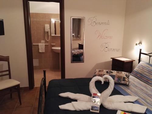 a bedroom with two swans towels on a bed at Agriturismo Agri Armonia in San Lucido