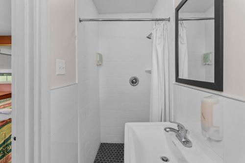 a white bathroom with a sink and a shower at Village Lodge in Bristol