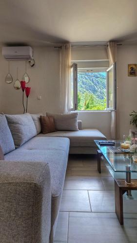 a living room with a couch and a window at Apartman Mara in Risan