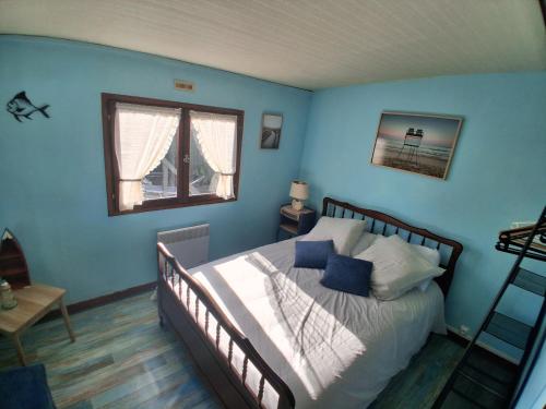 a bedroom with a large bed with blue walls at Gîte chez Kus in Changey