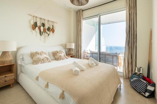 a bedroom with two beds and a large window at Bayview Hills Apartamento Andaluz in Torrox