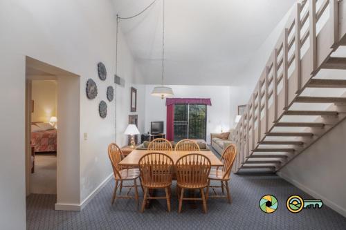 a dining room with a table and chairs and a staircase at Senedo Springs Condo #2-301 in Basye