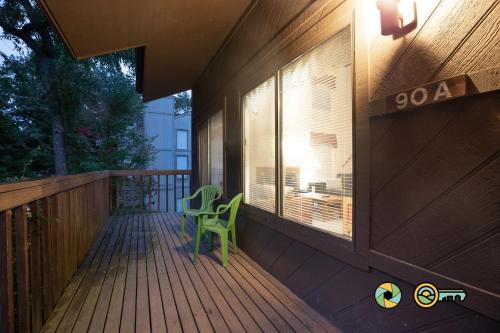 a porch with a green chair on a wooden deck at Senedo Springs Duplex #90A in Basye