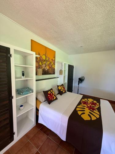 a bedroom with a bed and shelves in it at Heiva - Fare Orotia in Tiano
