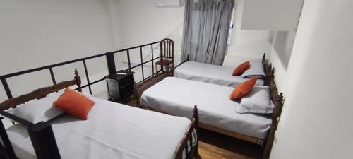 a room with two beds with orange pillows at El Refugio - Departamentos in Metán Viejo