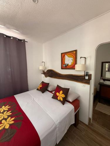 a bedroom with a white bed with flowers on it at Hiro'a - Fare Orotia in Taputapuapea