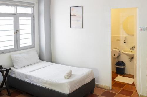 a small bedroom with a bed and a window at Casa Crespo in Cartagena de Indias