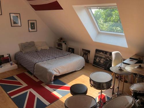 a bedroom with a bed and drums in a attic at Single-storey house in Saint-Cyr in Saint-Cyr-sur-Loire
