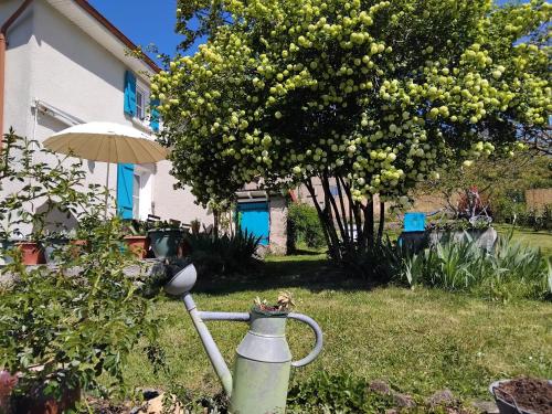 a watering can in a yard next to a house at La chambre du lac in Meaux-la-Montagne