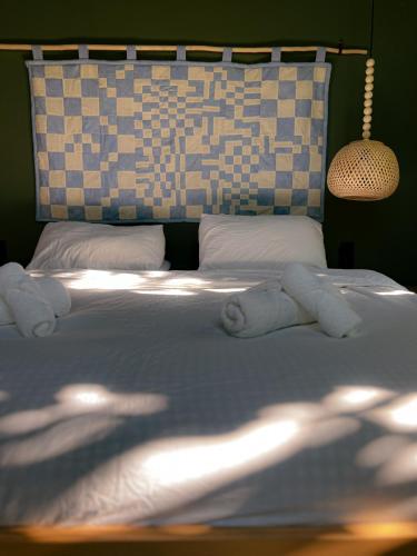 ein Schlafzimmer mit einem Bett mit weißen Laken und Kissen in der Unterkunft Karma Hostel in Martvili
