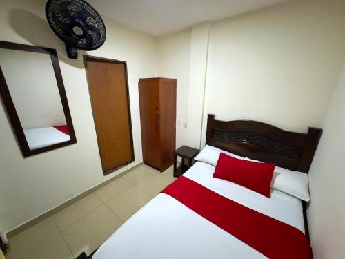 a bedroom with a red and white bed and a mirror at Hotel Tucan Pereira in Pereira