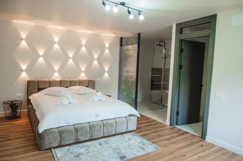 ein Schlafzimmer mit einem großen Bett mit weißer Bettwäsche in der Unterkunft Infinity View Chalet in Valea Doftanei