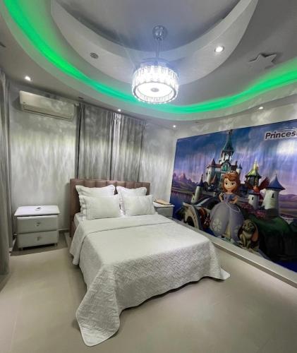 a bedroom with a bed with a painting on the wall at Residencial Paradise in San Francisco de Macorís