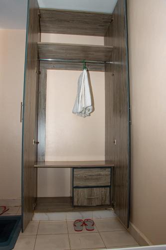 a room with a wooden shelf and a pair of scissors at Delore suits in Ongata Rongai 