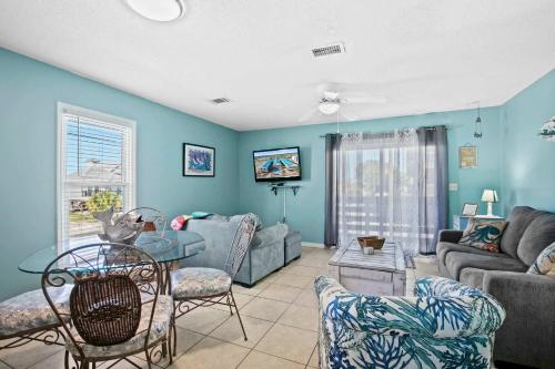 a living room with a couch and a table and chairs at Spacious 2BR Condo with Pool Across from the Beach in Gulf Shores