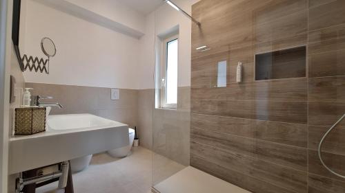 a white bathroom with a sink and a shower at Venti del Sud in Vieste