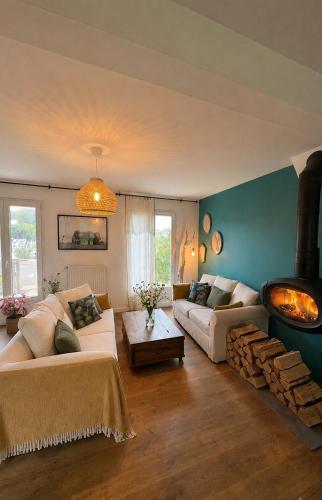 a living room with two couches and a fireplace at Chez Billie et Moon in Landéda