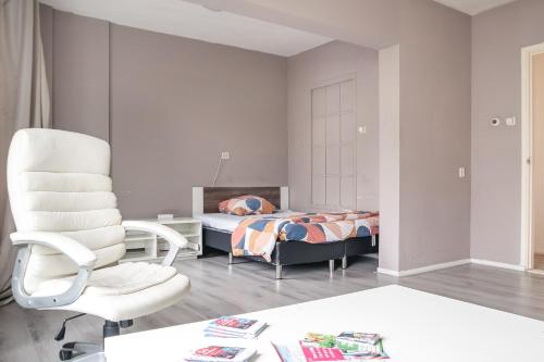 a bedroom with a bed and a chair at The Hague appartment in The Hague
