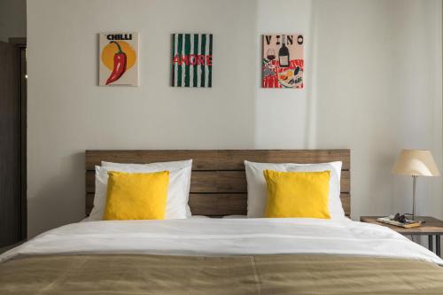 a bedroom with a bed with yellow pillows and posters at Sakis in Polychrono