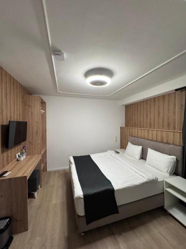 a bedroom with a large bed and a desk at DiDo Diamond Hotel in Dietzenbach